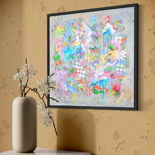 Colorful abstract painting on a beige wall with a vase and decorative branches below.