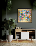 Modern living room with a colorful abstract painting on the wall, a wooden cabinet, and a plant.