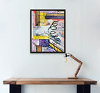 Abstract artwork on a wall above a wooden desk with a lamp.