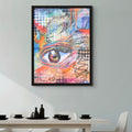 Framed abstract artwork with a colorful eye design on a wall above a dining table.
