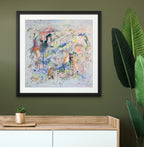 Framed abstract painting on a green wall with a wooden console table and plant.