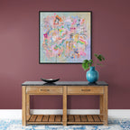 Wooden console table with decorative items against a purple wall with a colorful abstract painting.