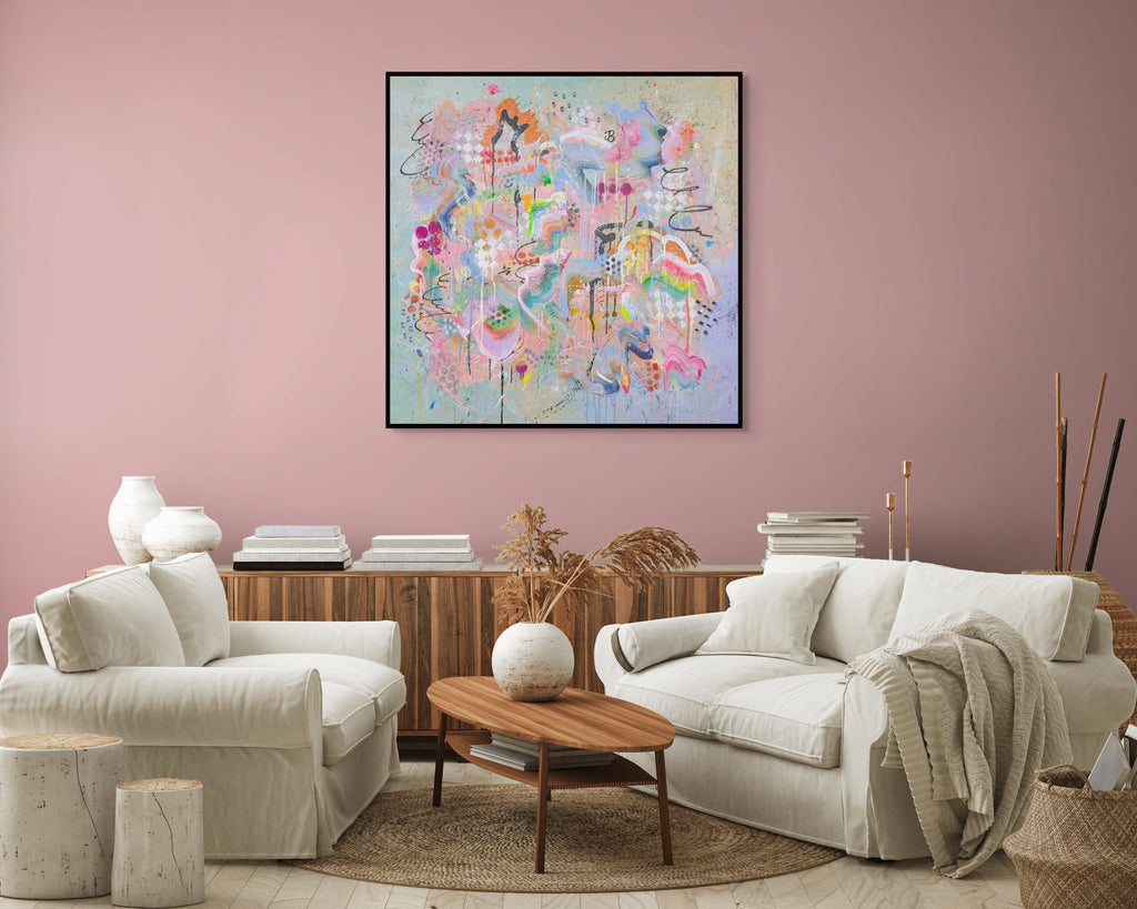 Living room with white sofa, coffee table, and colourful abstract painting on pink wall.