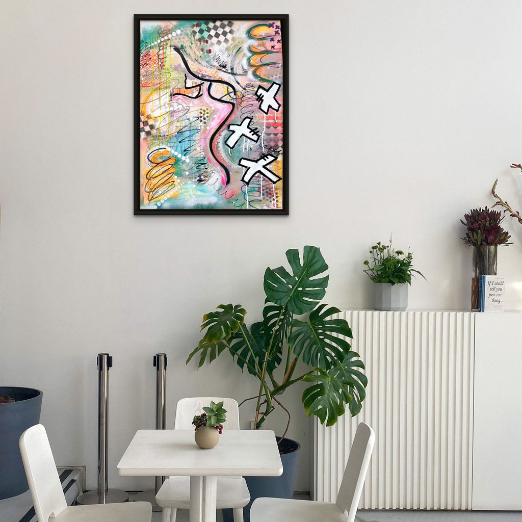 Modern interior with a colorful abstract painting on the wall, white table, chairs, and plants.